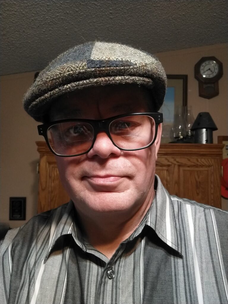 A man wearing glasses and a hat.